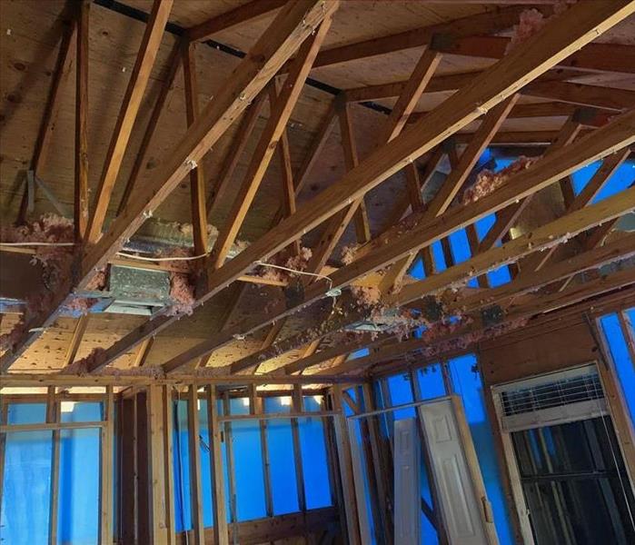 a room with removed drywall, just beams and rafters are showing